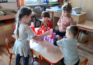 Dzieci układają kubeczki.